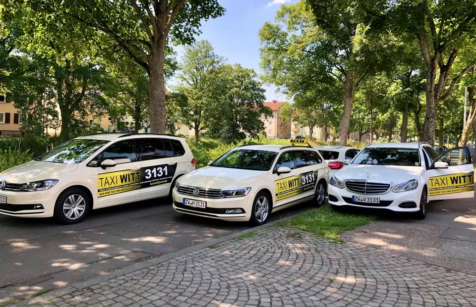 Taxi Witt Fahrzeugflotte parkt in einer grünen Straße