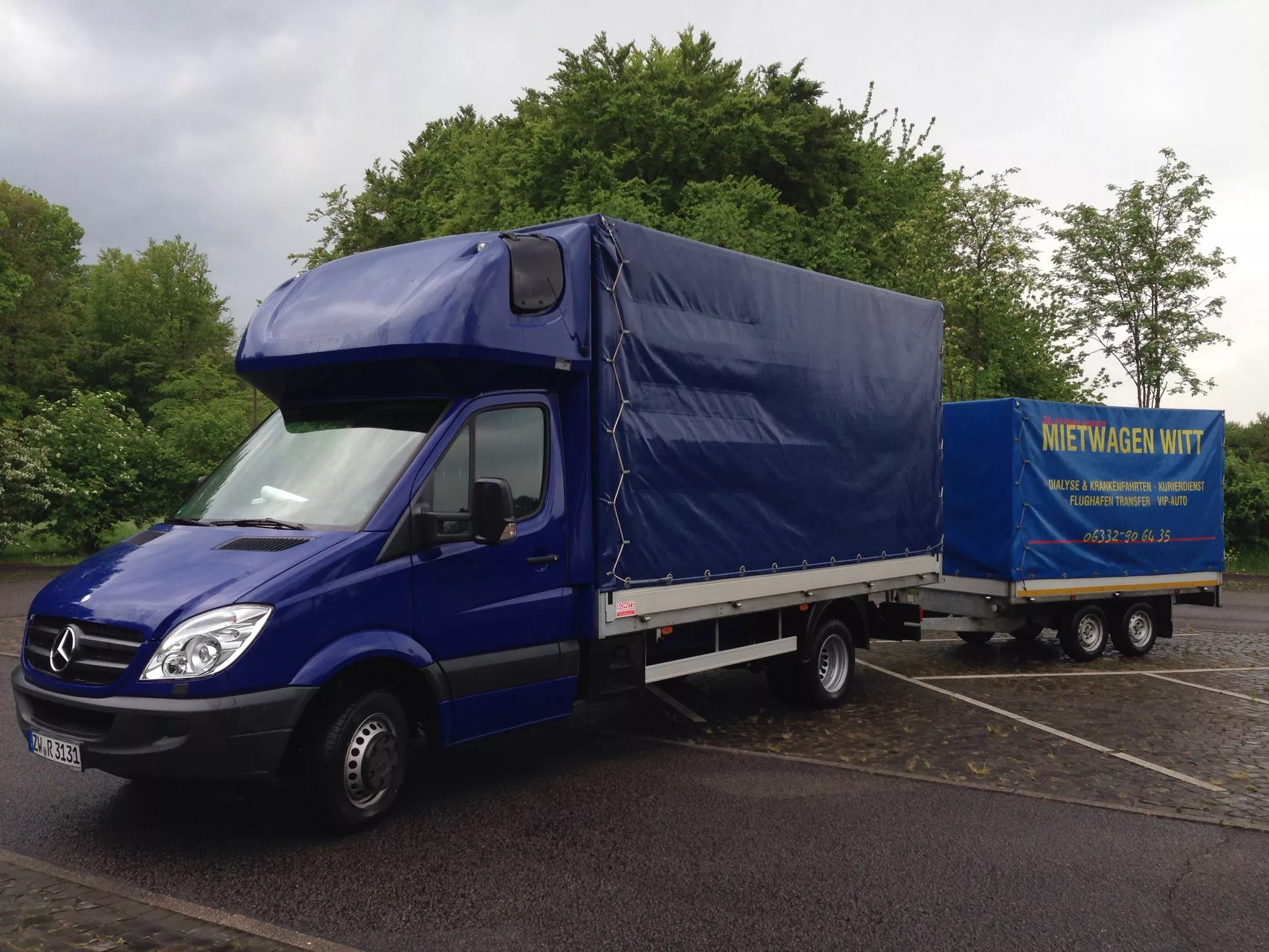 Mietwagen Witt Transporter mit Anhänger parkt auf einer Straße