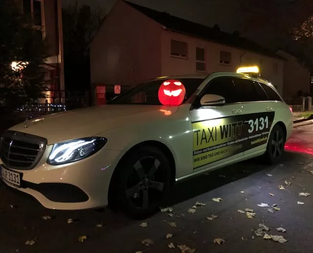 Taxi Witt Fahrzeug parkt bei Nacht auf der Straße