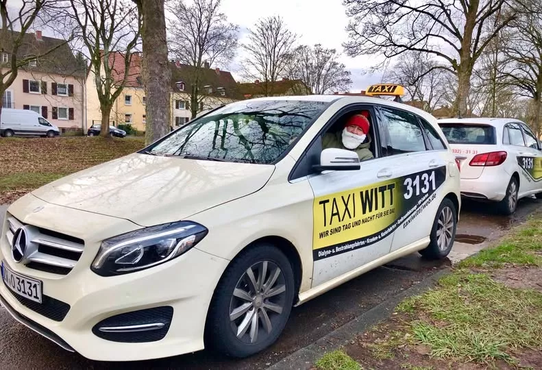 Taxi Witt Fahrzeug wird von einem Fahrer mit Nikolausmütze geparkt