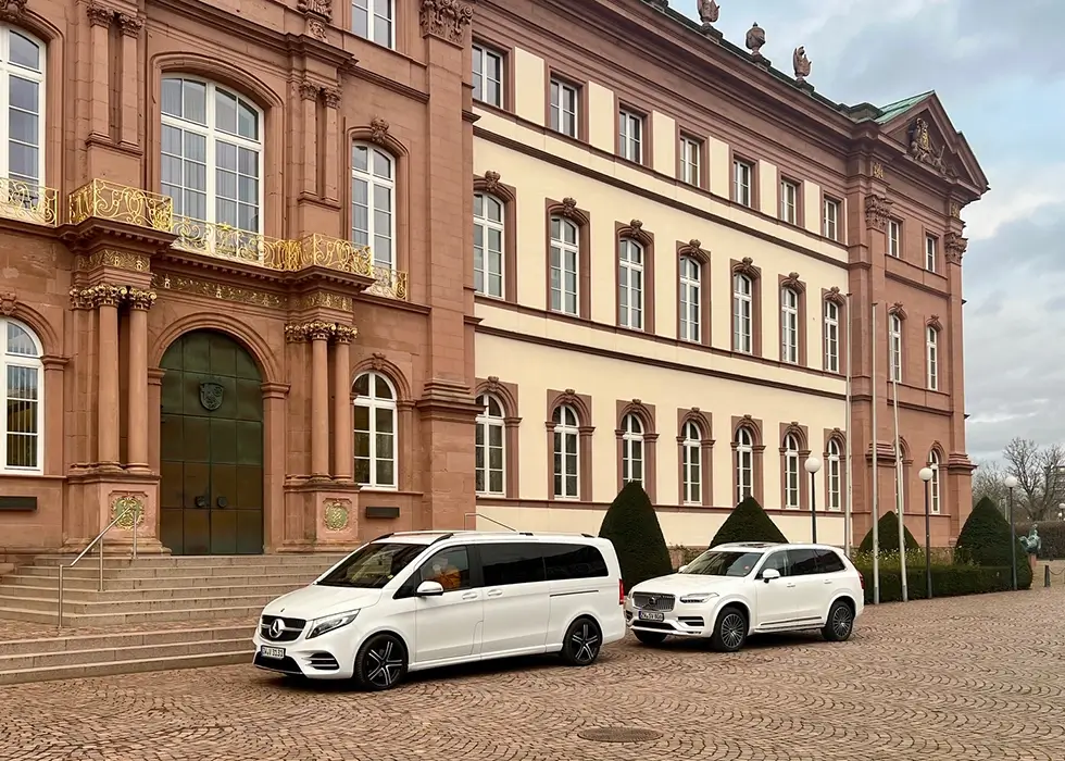 Zwei VIP Taxi Witt Fahrzeuge parken vor einem Schloss