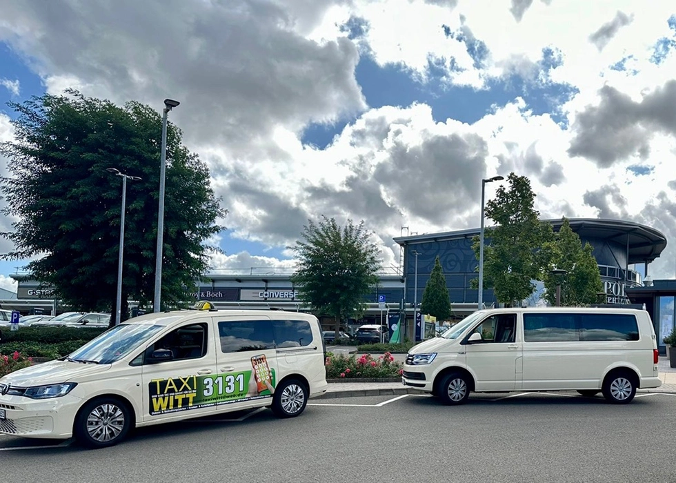 Großraumtaxi der Firma Witt parkt vor dem Flughafen