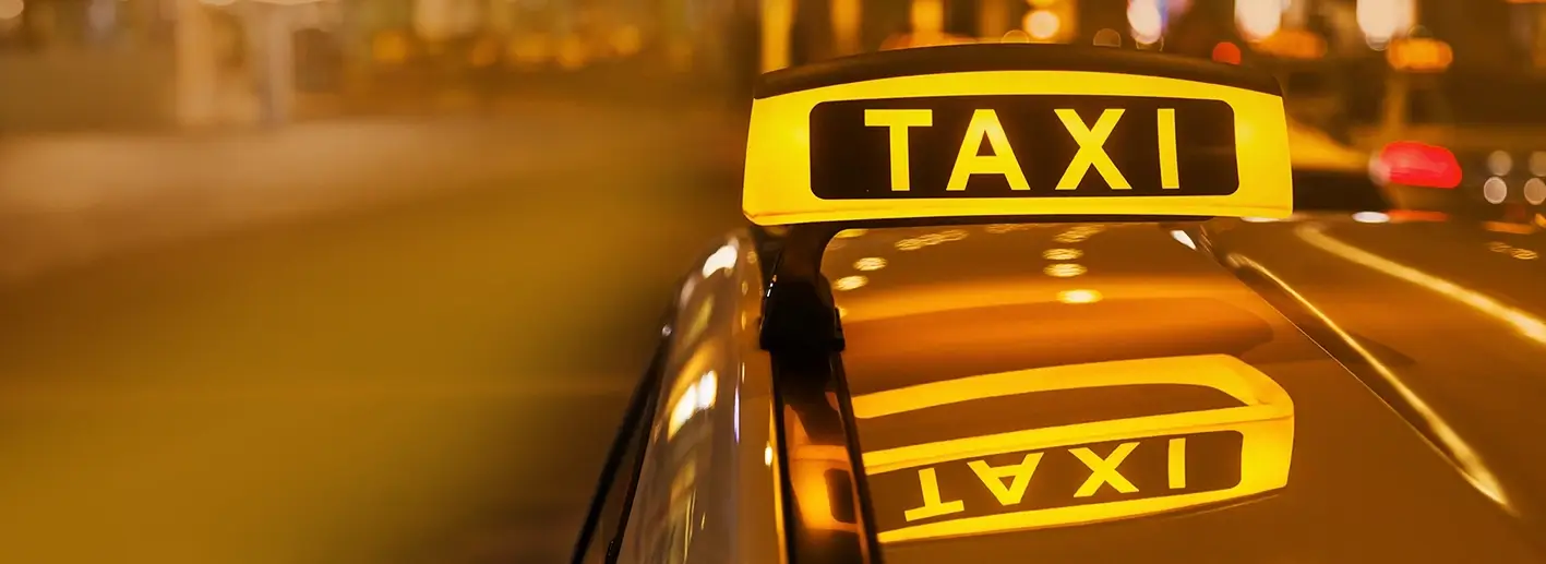 Ein Taxi fährt in der Nacht durch eine Stadt